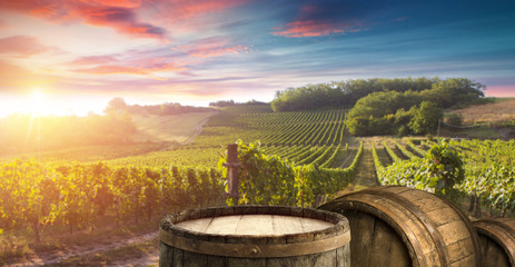 Rotweinflasche und Weinglas auf Holzfass. Schöner Toskana-Hintergrund