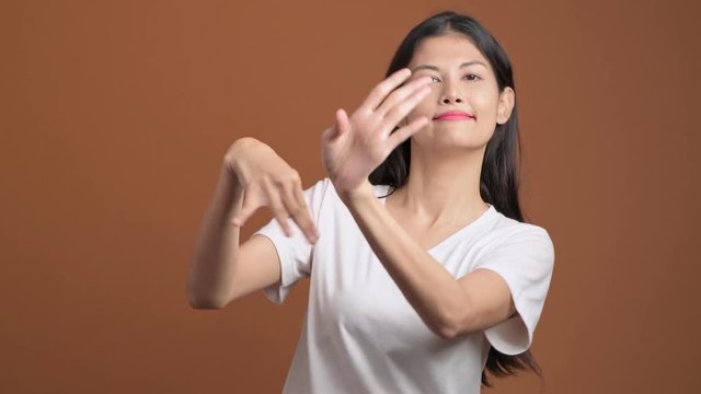 Thai traditional dance isolated. Thai woman in white t-shirt performing thai dance in front of camera.