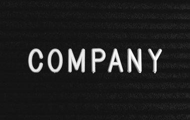 Word company written on the letter board. White letters on the black background