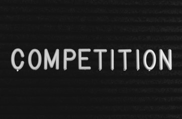 Word competition written on the letter board. White letters on the black background