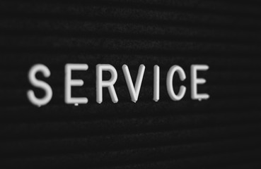 Word service written on the letter board. White letters on the black background