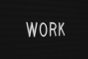 Word work written on the letter board. White letters on the black background