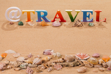 Fototapeta na wymiar travel written in colorful letters with sea shell at the beach with copy space