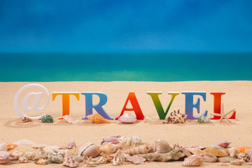 Fototapeta na wymiar travel written in colorful letters with sea shell at the beach with copy space