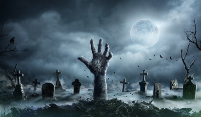 Zombie Hand Rising Out Of A Graveyard In Spooky Night - obrazy, fototapety, plakaty