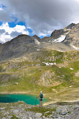 Fototapeta na wymiar hiker standing near of a blue lake in hight alpine mountain