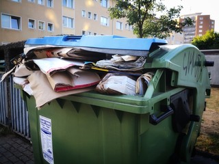 überfüllte Mülltonne im Wohngebiet