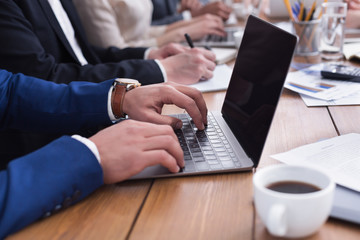 Fototapeta premium Businessman hands typing on laptop during meeting
