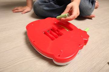 child hand insert batteries toy