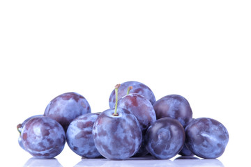 fresh ripe delicious plums stacked in a pile on a white isolated background