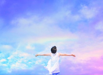 Fototapeta na wymiar Woman under beautiful rainbow sky background.