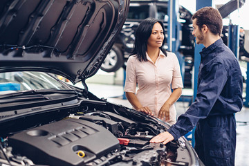 Auto car repair service center. The mechanic communicates with the client