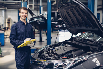 Auto car repair service center. Mechanic examining car engine