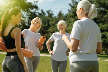 Friendly relations. Waist up shot of a group of retired woman smiling while listening to their trainer talking about their workout.