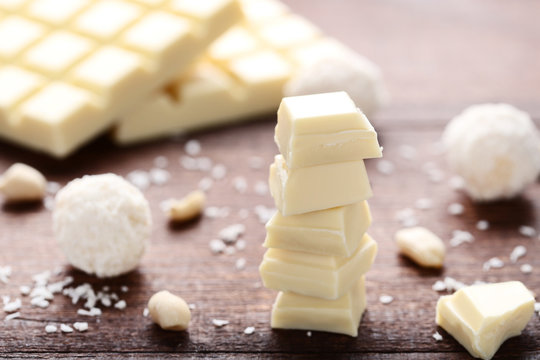 Chocolate pieces and coconut candies on wooden table