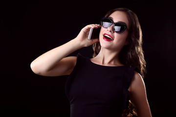 Young woman with smartphone on black background