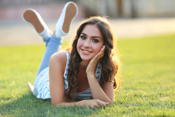 Young woman lying on green grass in the park