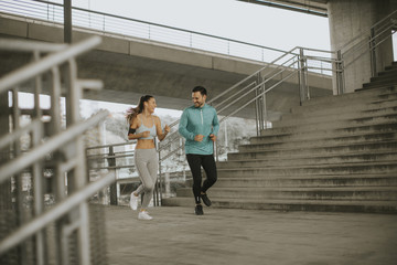 Young couple running in urban enviroment