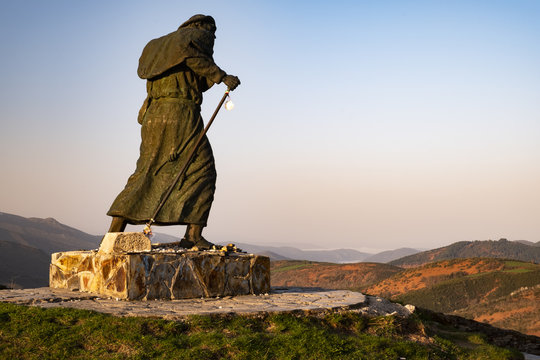 Statue eines Pilgers auf dem Jakobsweg mit Blick auf eine Gebirgskette nahe O Cebreiro bei Sonnenaufgang