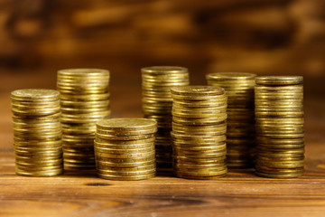 Stacks of golden coins on wooden background