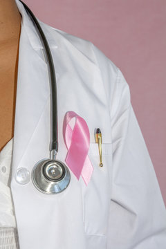 doctora usando lazo rosa de conciencia de c&aacute;ncer de mama con fondo rosado 