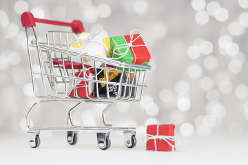 .The shopping cart is filled with different gifts for the holiday. Holidays Concept
