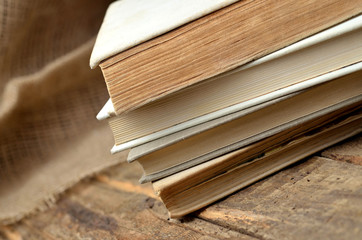 Stack of old books from the antiquarian bookshop on a rustic wooden table