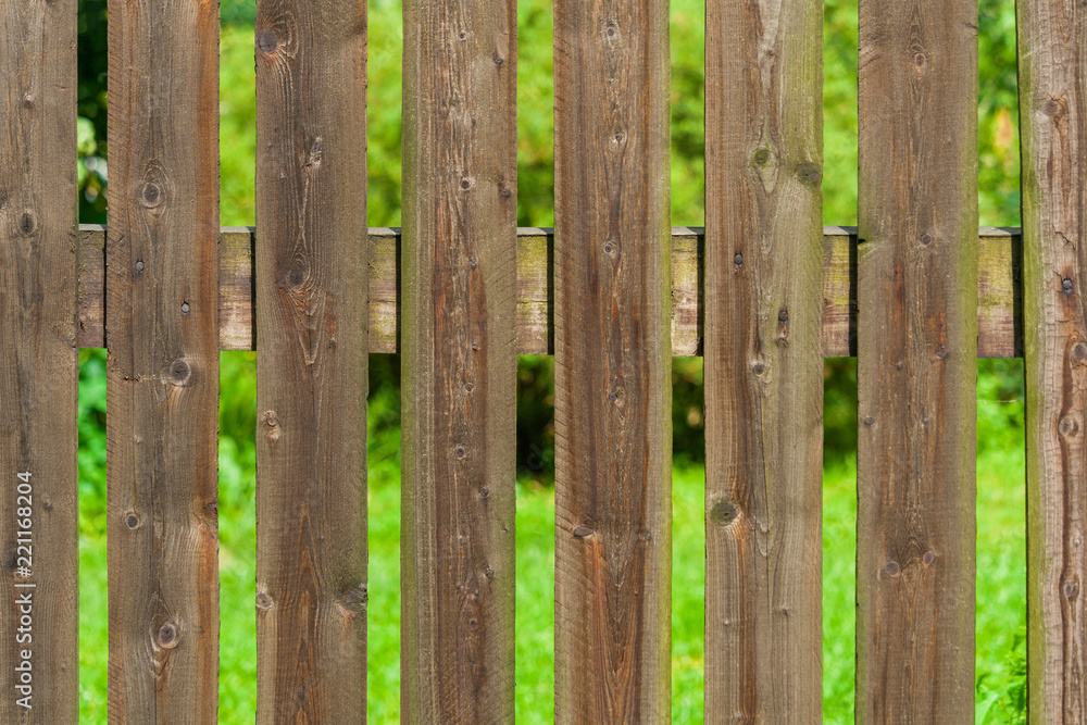 Wall mural rural wooden fence a background of green garden