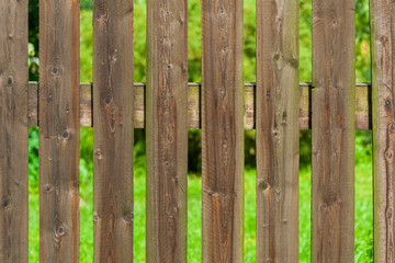 Rural wooden fence a background of green garden