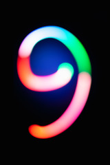 Digit 9. Nine. Glowing numbers on dark background. Abstract light painting at night. Creative artistic colorful bokeh. New Year. Use it for build you own design for book cover, poster or post card.