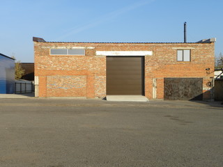industrial brick garage with high brown gate outside