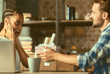 Is this a joke. Side view on an impressed young lady getting excited while listening to her boyfriend and receiving an unexpected gift from him.