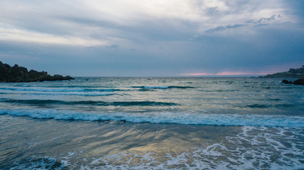 Beautiful sea with waves and white foam hitting the shore. Mediterranean sea. Evening. Dusk. Malta