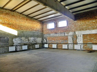 old damaged brick garage box with windows and a door inside