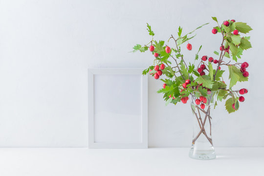 Mockup white frame and branches with red berries