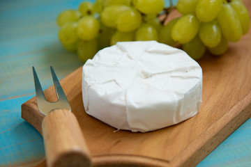 camembert, with a fork for cheese and grape