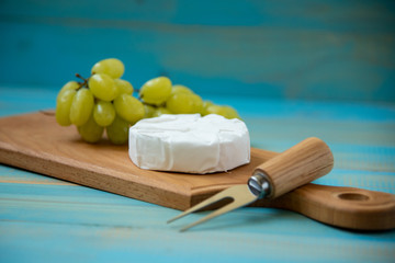 cheese camembert with a fork for cheese and grape