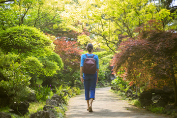 A girl is walking in a sunny garden and park on Jeju Island in Korea