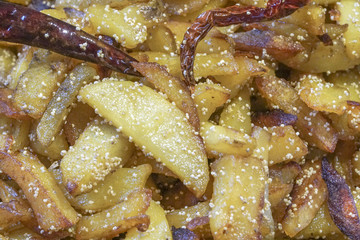 Fried potato pieces with fried red chilly
