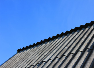 Rooftop Tiles at Countryside House Isolated on Empty Blue Sky Background. Construction Site Roofing Tiles and Modern Simple Roof Clad with Shingles on Sunny Summer Day 