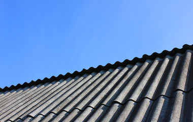 Roof Top Tiles Close Up View at Countryside House Isolated on Empty Blue Sky Background. Construction Site Roofing Tiles and Modern Simple Roof Clad with Shingles on Sunny Summer Day