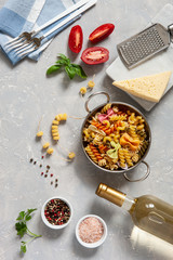 Ingredients for traditional pasta cooking - cheese, tomatoes, condiments. Top view, close-up on light concrete background