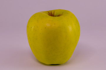 Yellow apple isolated on pink color background