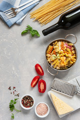 Ingredients for traditional pasta cooking - cheese, tomatoes, condiments. Top view, close-up on light concrete background