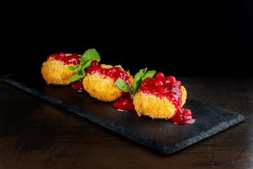 Cheese baked in batter is peppered with cranberry jam.