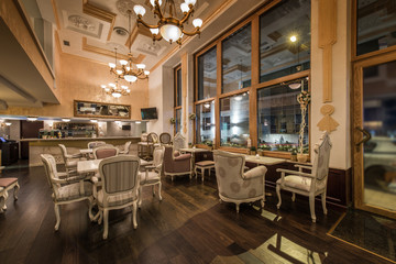 Restaurant interior with antique furniture and big classic chandeliers