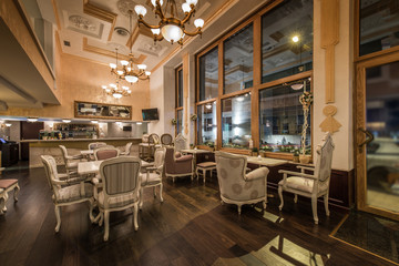 Fototapeta na wymiar Restaurant interior with antique furniture and big classic chandeliers