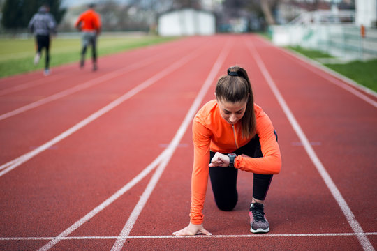 Female athlete on the starting line of a stadium track,ready to run