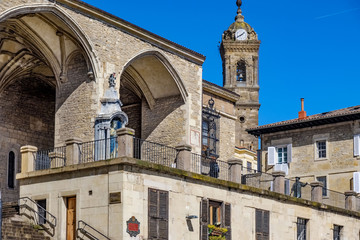 Obraz premium Bell tower with clock of the church of San Miguel Arcangel and typical houses of the north of Spain located in the Plaza de la Virgen Blanca in Vitoria Spain