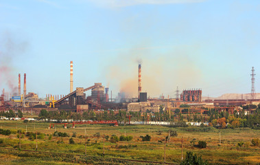 Fototapeta na wymiar Panoramic view of the large industrial plant with smoking factory chimneys on blue sky background.